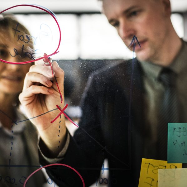 businesspeople-planning-glass-wall-min
